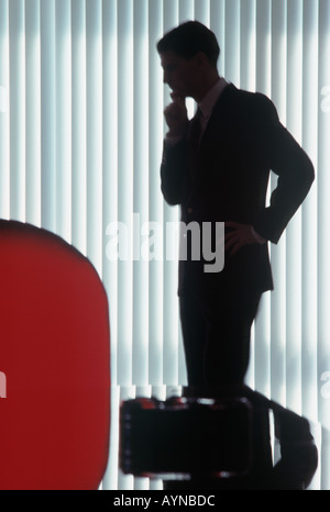 silhouette of an anonymous business executive deep in thought in his office Stock Photo