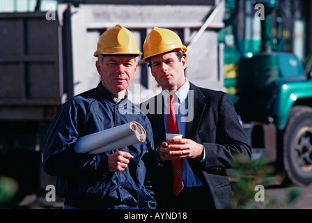 Portrait of two professionals on a job site, a construction foreman and architect with plans Stock Photo