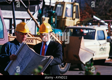 To professionals on a job site, a construction foreman and architect with plans Stock Photo