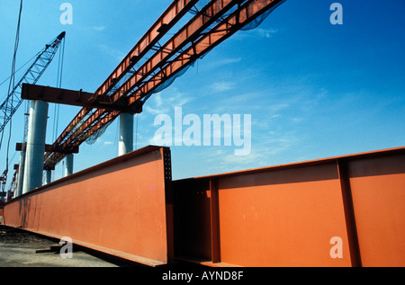 Steel girder staged and waiting to be put in place for an overhead highway construction project Stock Photo