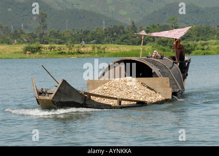 Sand dredging small motor boat on the Perfume river in central vietnam, this sand is extracted from the river bed Stock Photo