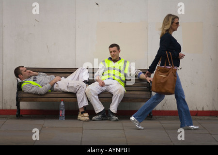 Resting Polish construction workers and passer by in Kings Road Chelsea London SW3 Stock Photo