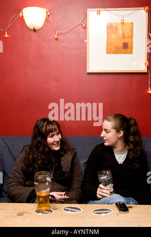 Two women talking and drinking together in Dublin Pub, Ireland Stock Photo