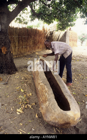 Villager carving out a dugout canoe in the village of Chembe,Cape Maclear, Lake Malawi, Malawi Stock Photo