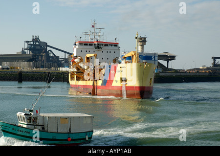 fishing boat passing the dredger rene gibert in Boulogne sur Mer Harbour France Europe Stock Photo