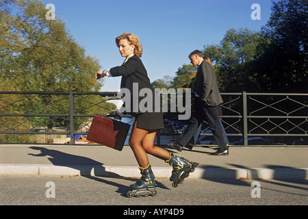 Businesswoman roller blading on bridge over canal on way to work in Stockholm Stock Photo