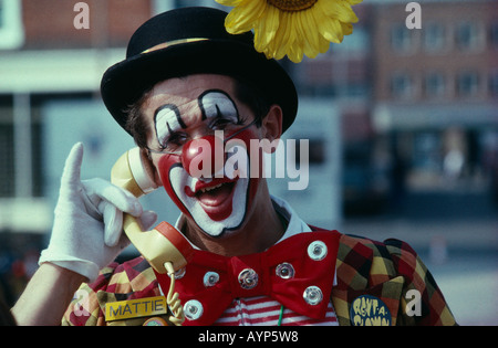 England West Sussex Bognor Regis Clown Convention Clown in full makeup holding the hand piece of a phone to his ear and laughing Stock Photo