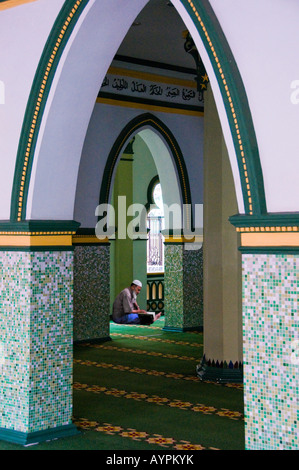 Muslim man sitting in prayer hall at Masjid Abdul Gafoor Mosque in Little India area of Singapore Stock Photo