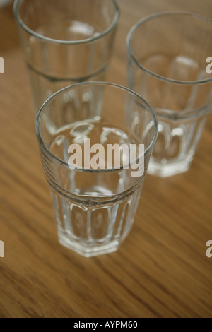 Three empty glasses kept on a table Stock Photo