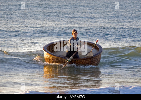 Vietnamese fisherman in his basket boat on the beach at Mui Ne, Vietnam, Southeast Asia, Asia Stock Photo
