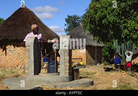 Woman lifting water from the new upgraded family well which will provide clean drinking water for several other families too. Nr. Kwekwe, Zimbabwe Stock Photo