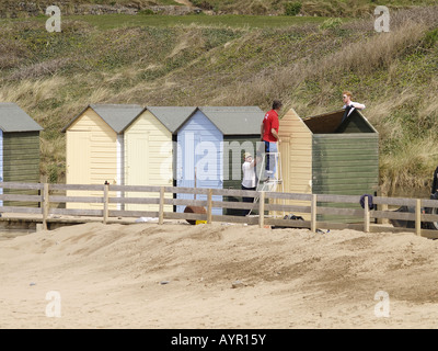 Colourful beach huts at summerleaze beach, Bude, Cornwall, UK, being put back in place ready for the summer season. Stock Photo