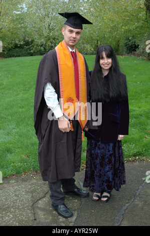 portrait of woman with son wearing graduation gown Stock Photo