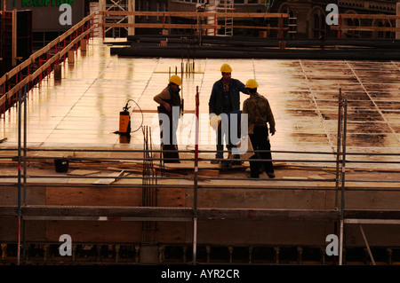 Construction workers talking at a construction site, building shell Stock Photo
