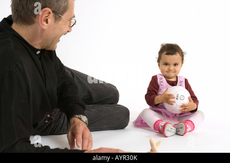 Father watching his young daughter play Stock Photo
