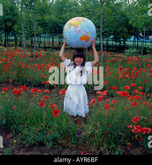 girl standing in poppy field holding big globe. Photo by Willy Matheisl Stock Photo