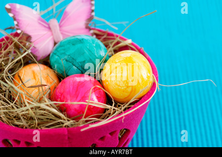 Nest made of straw with eggs in a basket, close-up Stock Photo
