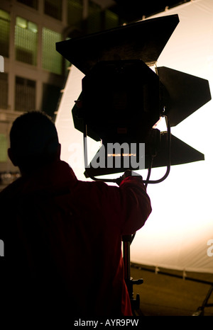 Lighting technician setting up a floodlight on a film set in Germany, Europe Stock Photo