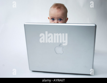 Six month old baby boy working on a laptop computer Stock Photo