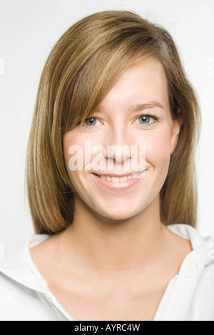 Portrait of smiling young woman with long dark-blonde hair Stock Photo