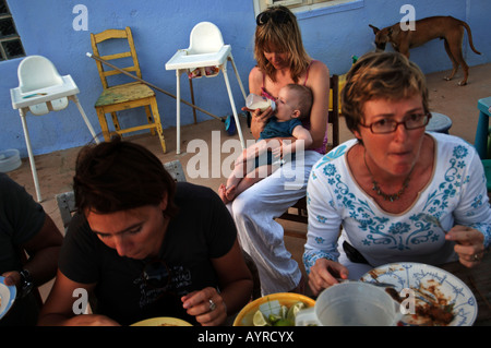 Netherlands Antilles Curacao a baby boy being bottle fed by his mother during lunch Stock Photo