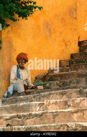 Beggar sitting on stairs in traditional clothing, Jaipur, India Stock Photo