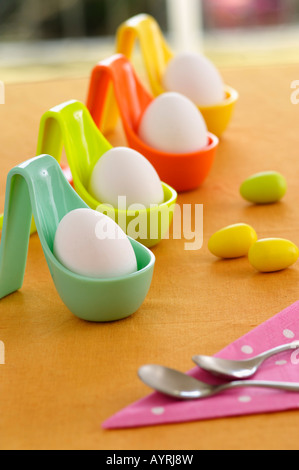 Four eggs in plastic cups on a table, selective focus Stock Photo