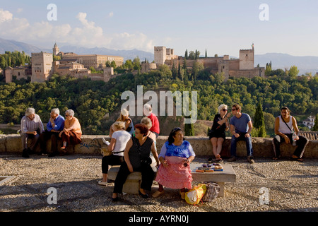 Tourists at Mirador de San Nicolas lookout point enjoying the view of the Alhambra, Moorish castle, seat of the Nasrid dynasty  Stock Photo