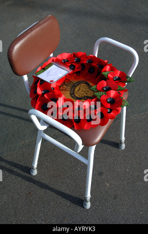 A poppy wreath on an elderly persons chair during a Remembrance Service Stock Photo