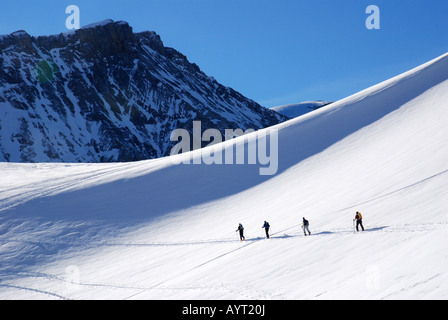 Ski mountaineers walking up to Ammertenspitze with Wildstrubel in back, Bernese Oberland Alps, Switzerland Stock Photo