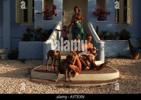 Netherlands Antilles Curacao expat family posing on the steps of their historical colonial Dutch cottage Stock Photo