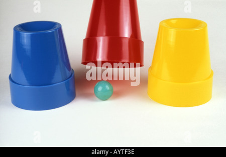 Shell game with three plastic cups and marble Stock Photo - Alamy