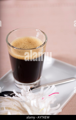 A glass of coffee and a teaspoon Stock Photo