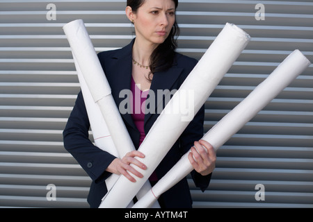 Businesswoman holding several paper rolls Stock Photo