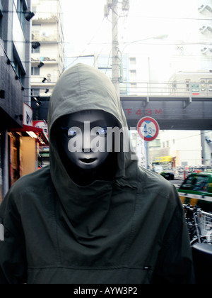 Robot wearing a hooded anorak in an urban environment Stock Photo