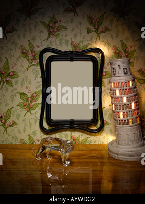 A blank frame hanging on a wall in a living room type scene with sideboard and ornaments. Stock Photo