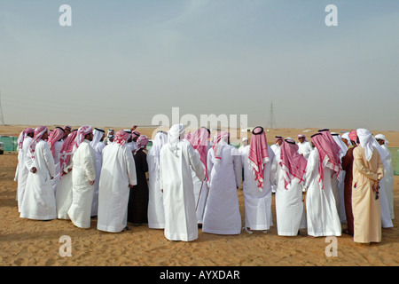 Male participants and spectators at the Al Dhafra camel festival in the desert near Madinat Zayed, Abu Dhabi, UAE. Stock Photo