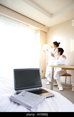 a couple using the laptop computher and drinking a coffee on the bed Stock Photo