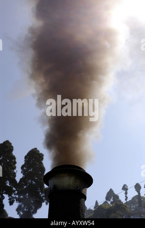 Thick smoke billows from the chimney of the famous Darjeeling Toy Train in Darjeeling, West Bengal, India, Asia. Stock Photo