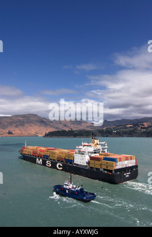 A container ship sails from Lyttelton, New Zealand, as viewed from a cruise ship. Stock Photo