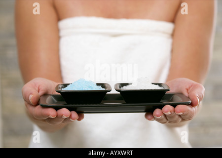 Young woman holding dishes with salt crystals Stock Photo