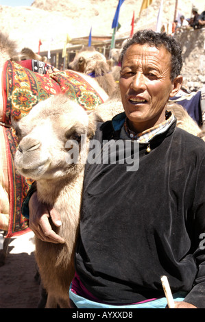 Ladakhi man with a Bactrian Camel during the Ladakh Festival in Leh, Ladakh, India. A portrait of a local man and his camel in the Himalayas. Stock Photo