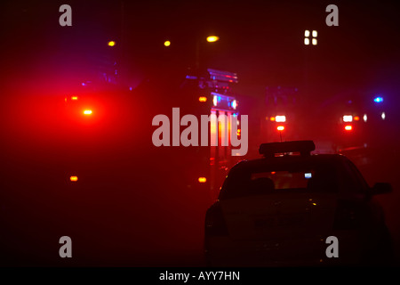 northern ireland fire and rescue service fire tenders trucks sitting at the roadside with firechiefs car in smoke Stock Photo