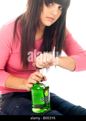 Young Underaged Teenage Girl Sitting On The Floor Alone Experiencing  Inflicted Alcohol Abuse Drinking Alcohol Wearing A Pink Top And Blue Denim Jeans Stock Photo
