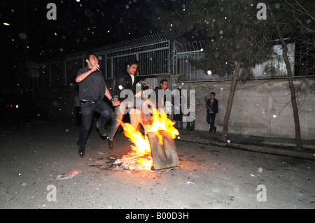Iranian people jumping over bonfires during the festival of fire prior to the Persian new year, iphoto taken in Tehran, Iran. Stock Photo
