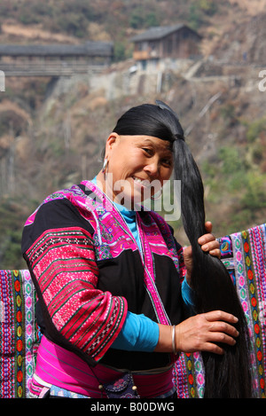 Yao woman with very long black hair demonstrates hair combing at Longji rice terraces, Pingan village, Longsheng County, China Stock Photo