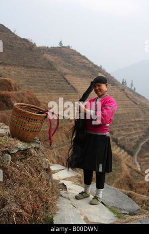Yao woman with very long black hair demonstrates hair combing at Longji rice terraces, Pingan village, Longsheng County, China Stock Photo
