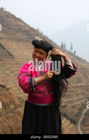 Yao woman with very long black hair demonstrates hair combing at Longji rice terraces, Pingan village, Longsheng County, China Stock Photo
