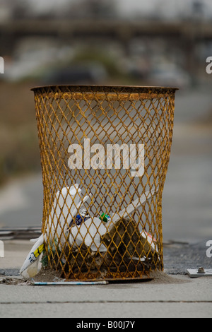 Typical New York City garbage can, with garbage falling out of it.  Far Rockaway, NY, USA Stock Photo