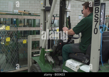 Forklift driver moving glass panel in glass factory Stock Photo